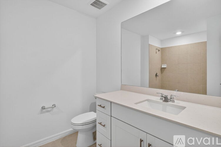 A bathroom with a toilet, sink, and mirror.