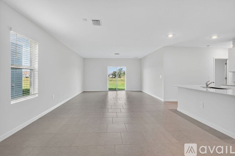 A spacious, empty room with a large window and a view of the outdoors.