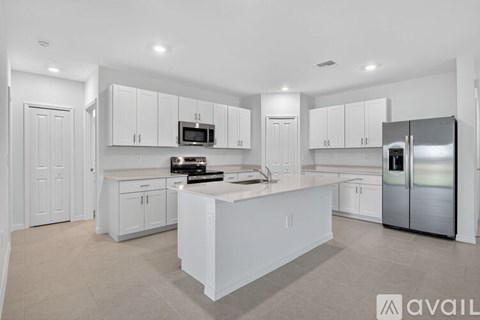 A modern kitchen with white cabinets and appliances.