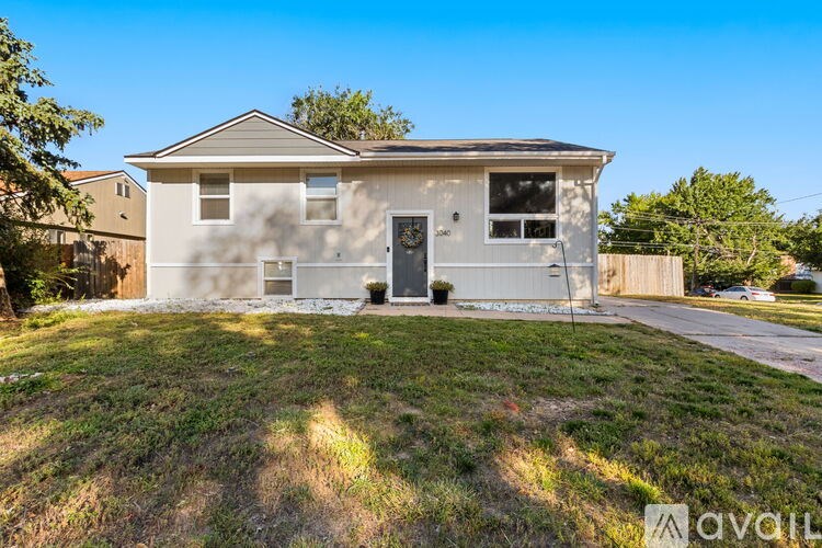 A two-story house with a front yard and a fence.
