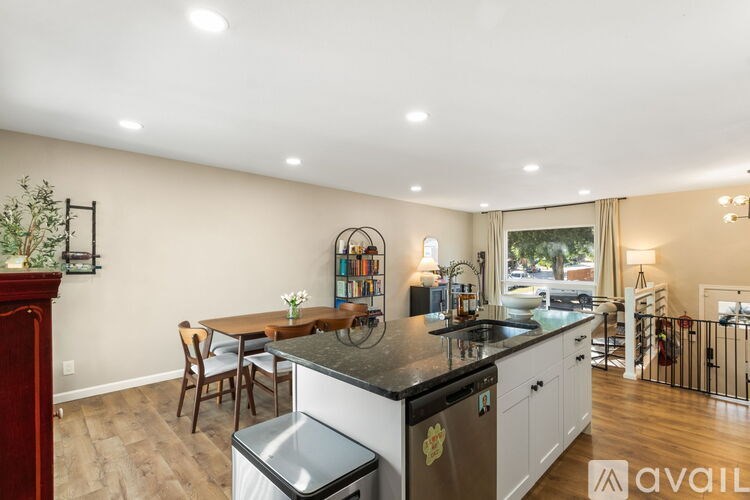 A kitchen with a black countertop and white cabinets.