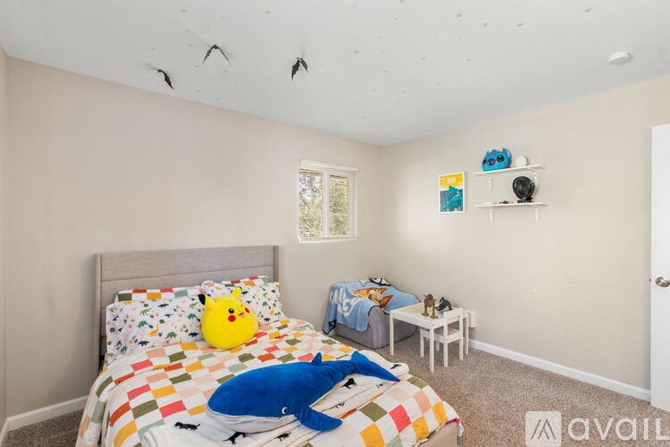 A room with a bed, a small table, and a window.