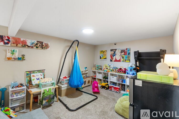 A child's playroom with a blue umbrella and toys.