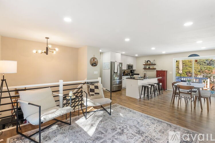 A living room with a white sofa and a dining table with chairs.
