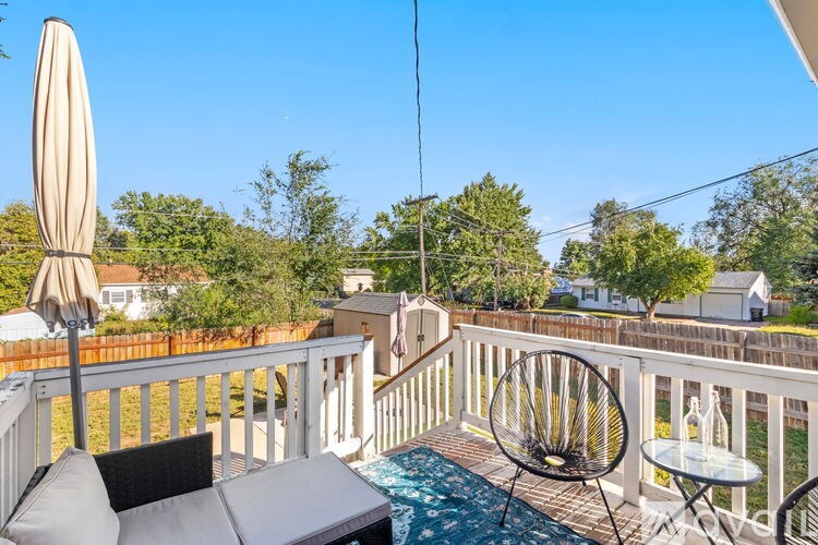 A sunny day on a balcony with a table and chairs.