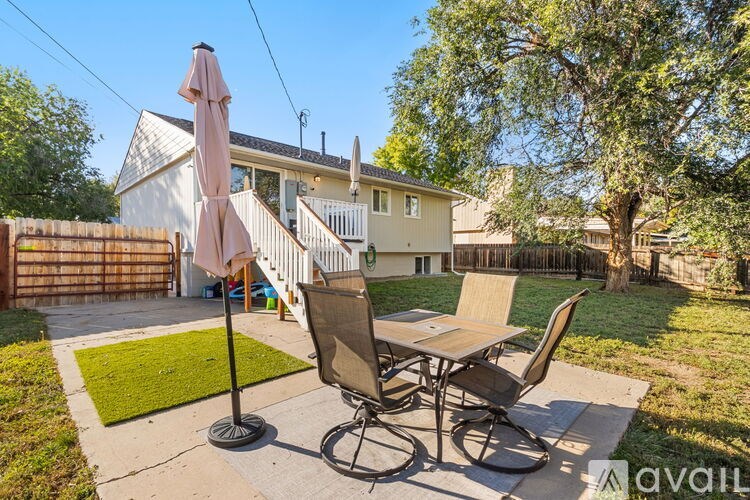 A patio with a table and chairs and an umbrella.