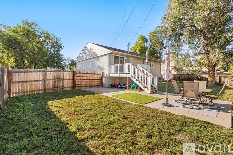 A house with a fence and a lawn in front of it.