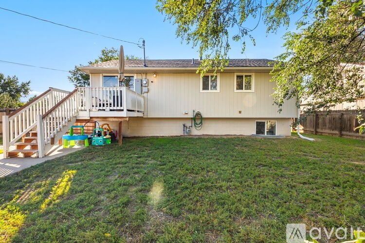 A house with a white exterior and a deck with a table and chairs.