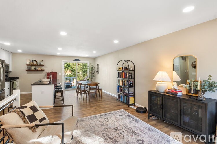 A well-lit living room with a checkered chair and a bookshelf.