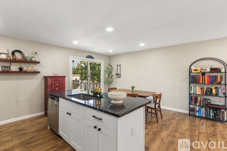 A kitchen with white cabinets and a black countertop.