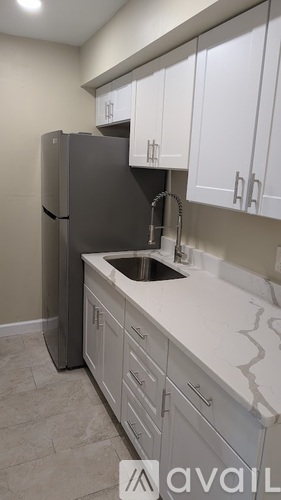 A kitchen with a sink and a refrigerator.