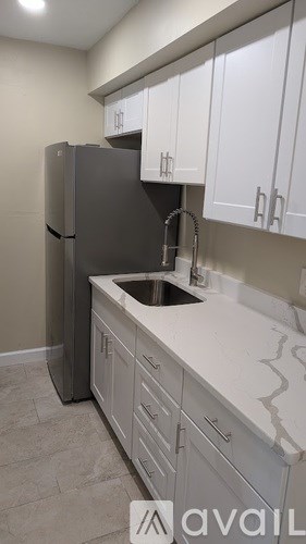 A kitchen with a sink and a refrigerator.