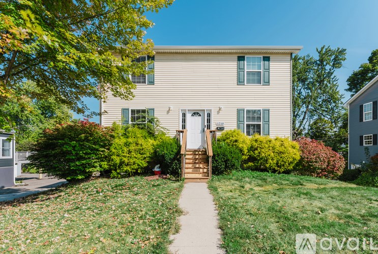 A house with a white door and a small porch with a step up to it.