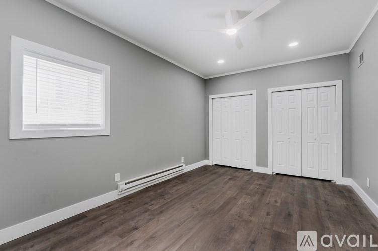 A room with a window and two doors is available for rent.