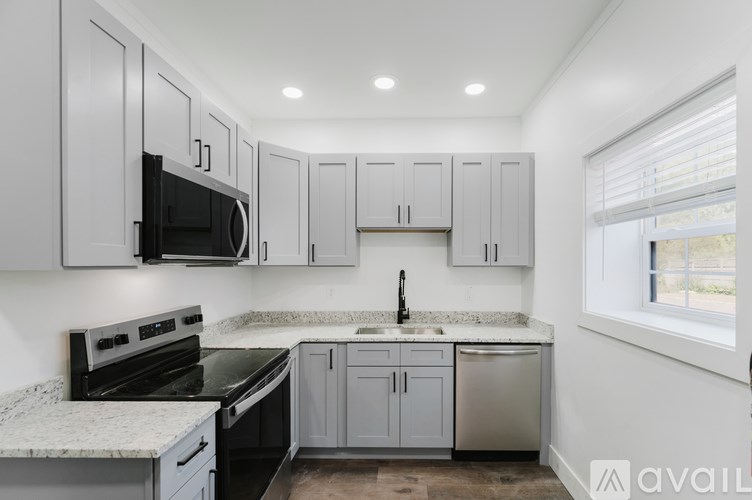 A kitchen with white cabinets and a granite countertop.