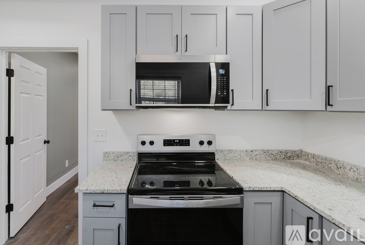 A kitchen with a black microwave above a stove.