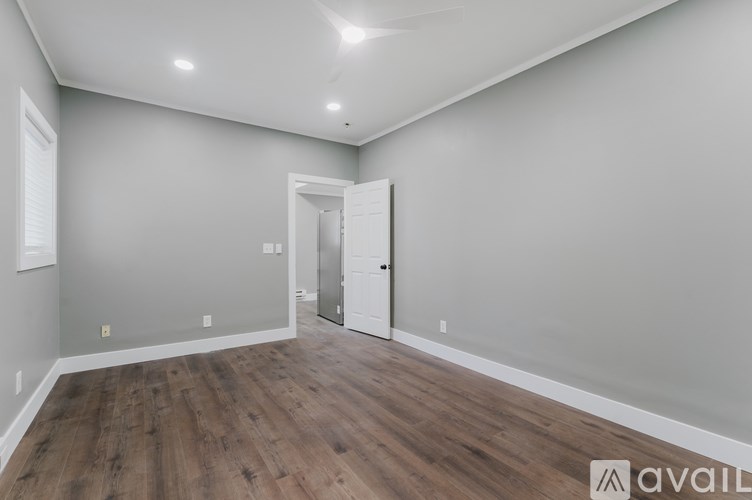 A room with wooden flooring and a white door.