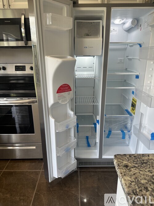 A white refrigerator with its door open in a kitchen.