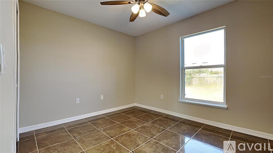 A room with a ceiling fan and a window.