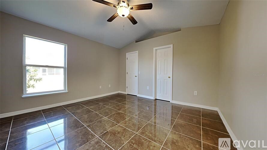 A room with tile flooring and a ceiling fan.