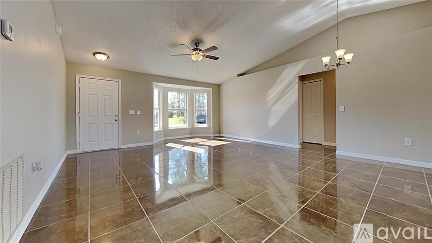 A spacious room with a tiled floor and a ceiling fan.