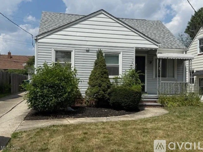 A house with a grey roof and a white siding is for sale.