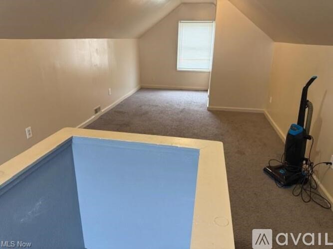 A room with a blue pool table and a vacuum cleaner.