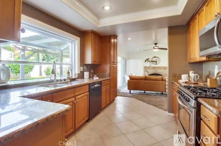 A kitchen with wooden cabinets and a marble countertop.
