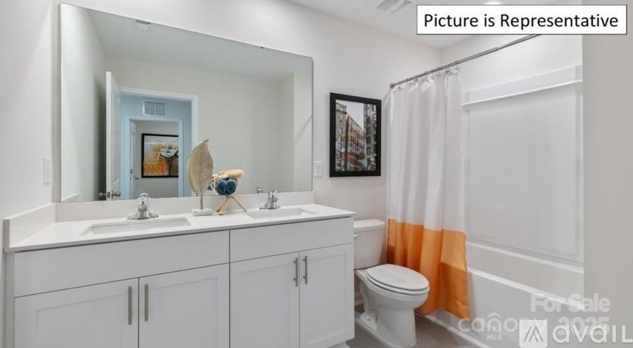 A bathroom with a white toilet, a sink with a mirror above it, and a shower curtain.