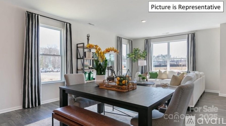 A dining room with a table set for four and a couch with pillows.