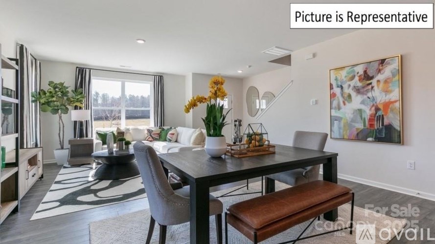 A dining room with a table set for two and a painting on the wall.