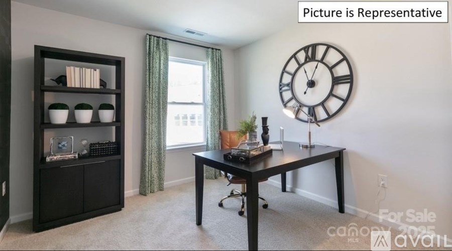 A room with a desk, a clock, and a cabinet with a shelf.