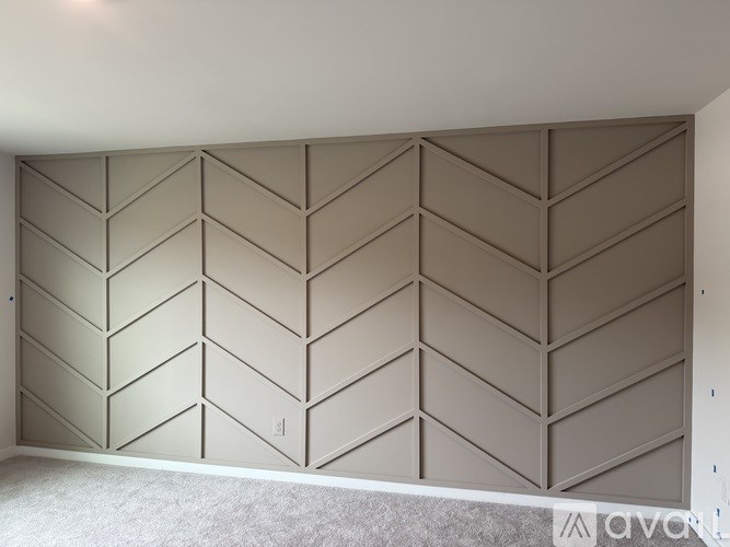 A room with a white ceiling and a wall with a geometric pattern.