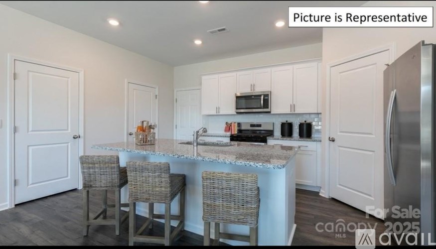 A kitchen with a table and chairs in front of it.