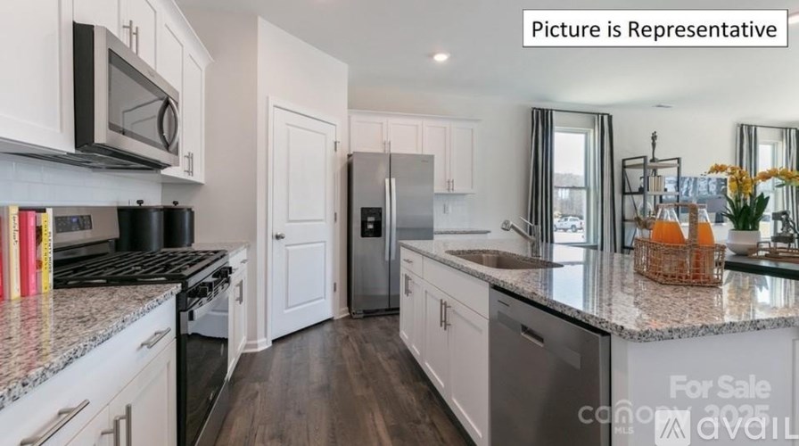 A kitchen with a refrigerator, stove, and sink.