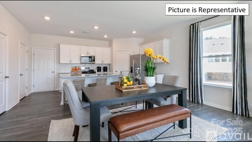 A dining area with a table set for two and a kitchen in the background.