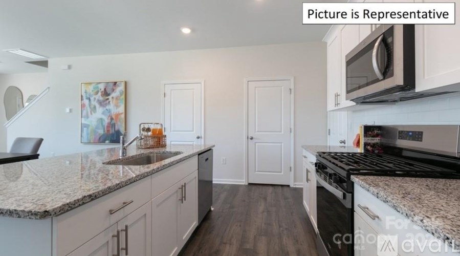 A kitchen with a granite countertop and a stainless steel oven.
