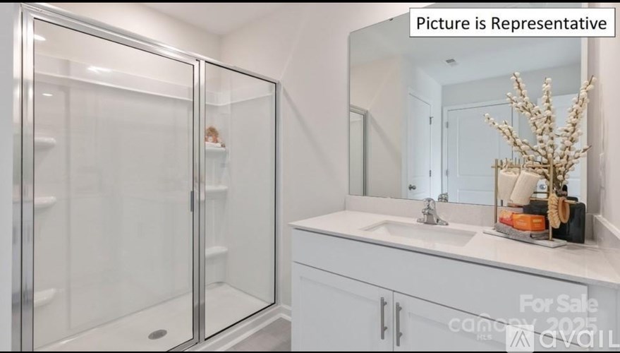 A bathroom with a glass shower door and a white sink vanity.