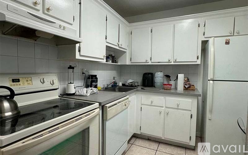 A kitchen with white cabinets and a stainless steel stove top.