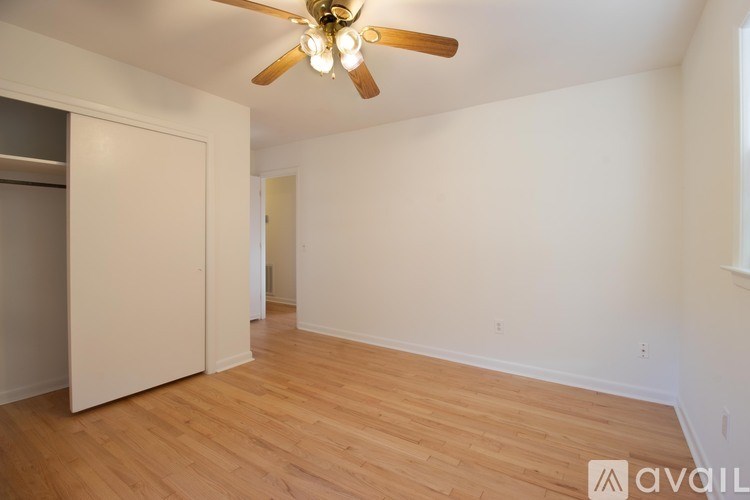 A room with a ceiling fan and wooden flooring.