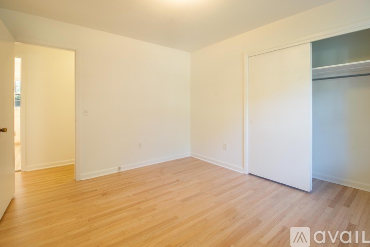 A room with wooden flooring and white walls.