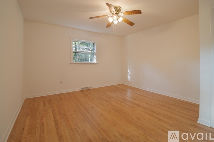 A room with wooden flooring and a ceiling fan.