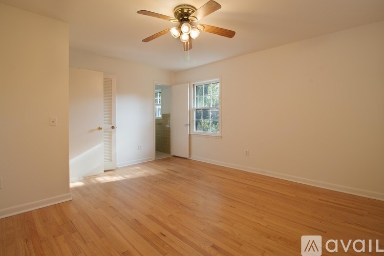 A room with wooden floors and a ceiling fan.