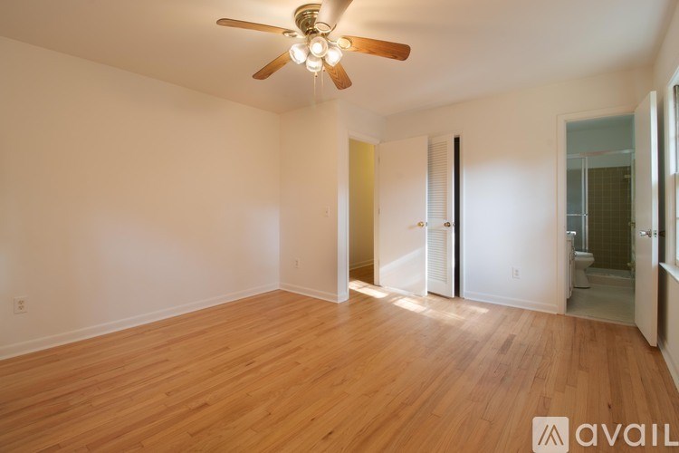 A room with a ceiling fan and wooden flooring.