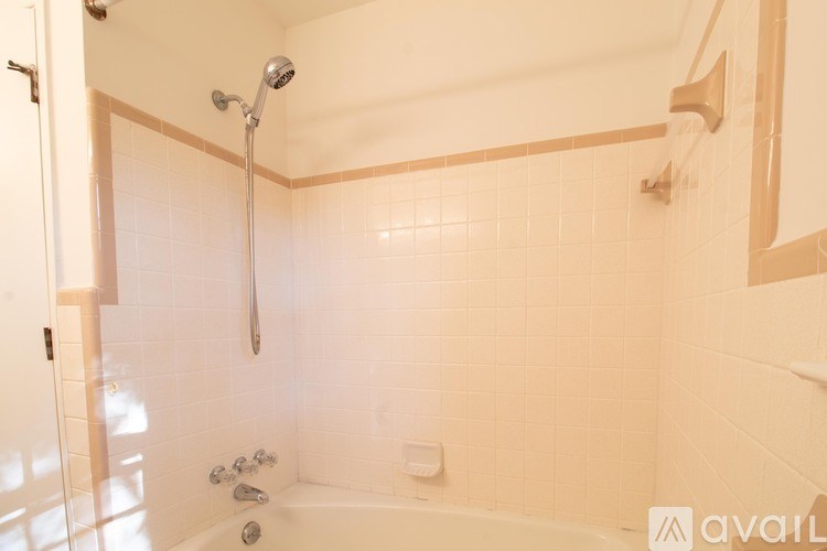 A bathroom with a white tub and a shower head.
