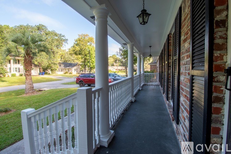 A porch with a white railing and pillars.