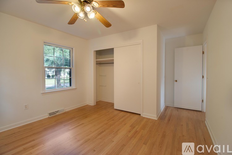 A room with a ceiling fan and wooden flooring.