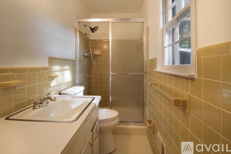 A bathroom with a toilet, sink, and shower.