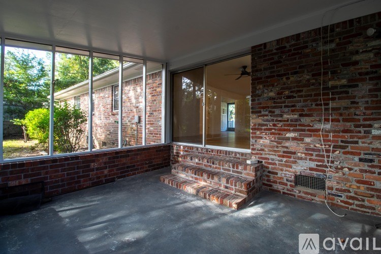 A room with a brick wall and a ceiling fan.