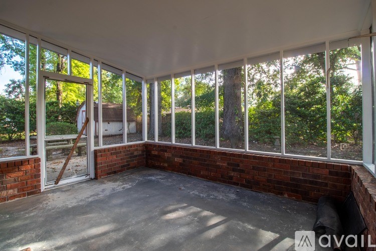 A room with a white ceiling and a brick wall with a large window.